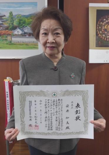 表彰状を持つ安井和美さん