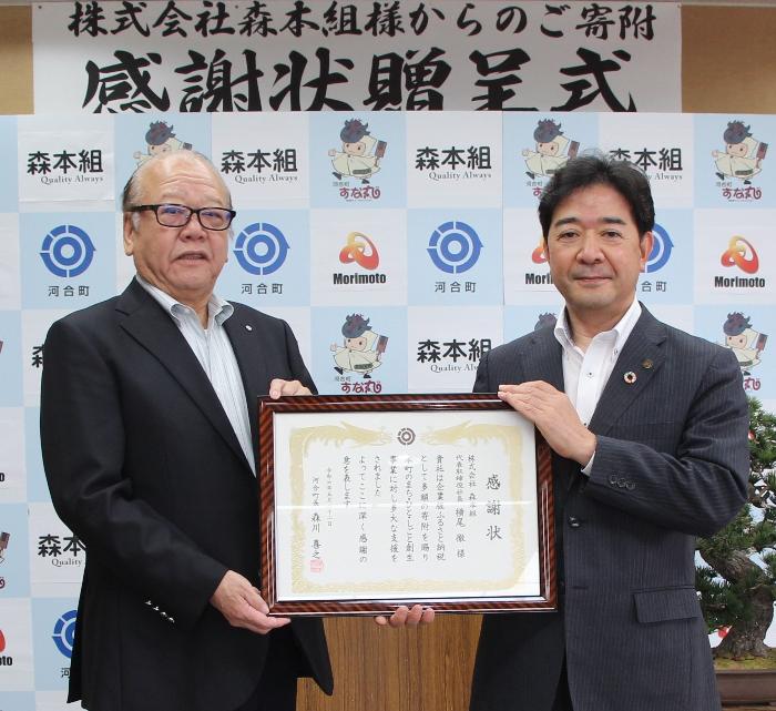 森本組執行役員と河合町長が持つ感謝状の写真